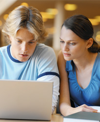 Photograph of two students looking at a laptop. There are many ways for students and families to obtain information about higher education costs and higher ed professionals need to use these tools to meet the expectations of the students they want to enroll.