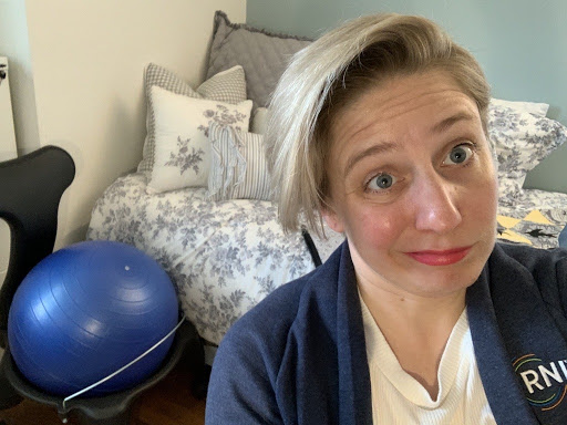 Greta Daniels working at home, with her very neglected balance ball behind her.