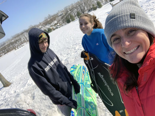 Amy Weiss of RNL and her two children on a mountain skiing.