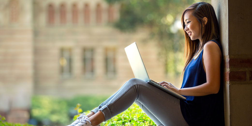 Four Enrollment Strategies: image of female student on laptop on campus