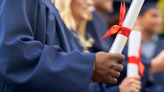 Is college student retention an investment? Man holding a diploma