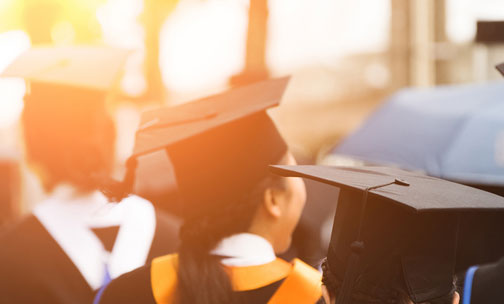 College student graduates in cap and gowns