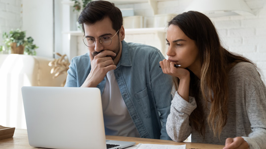 Couple looking at college financing offer on a computer screen