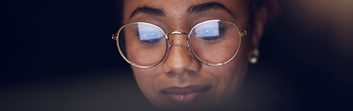 RNL Instructional Design: Image of a female student looking on a screen with the reflection in her glasses.