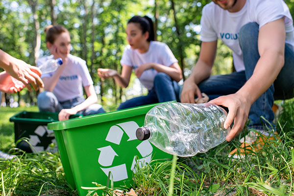 Blog on Alumni Giving: Image of volunteers picking up plastic bottles for recycling. 