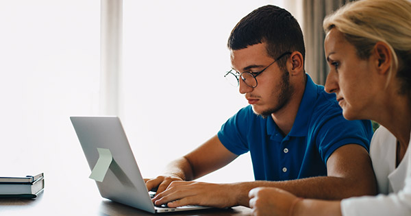 Blog on families and college costs: Image of a mother and son looking at a computer screen