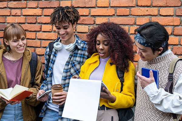 Making the Most of College Fairs and High School Visits: Group of multiracial high school students looking over notes