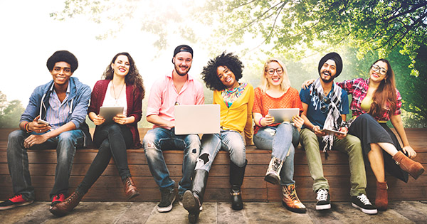Blog on Student Research in 2025: Image of 7 college students sitting under a tree.