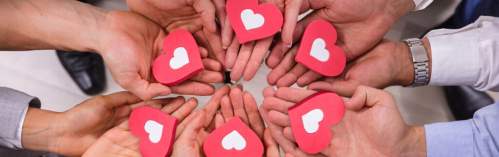 Crowdfunding: six hands holding red and white hearts